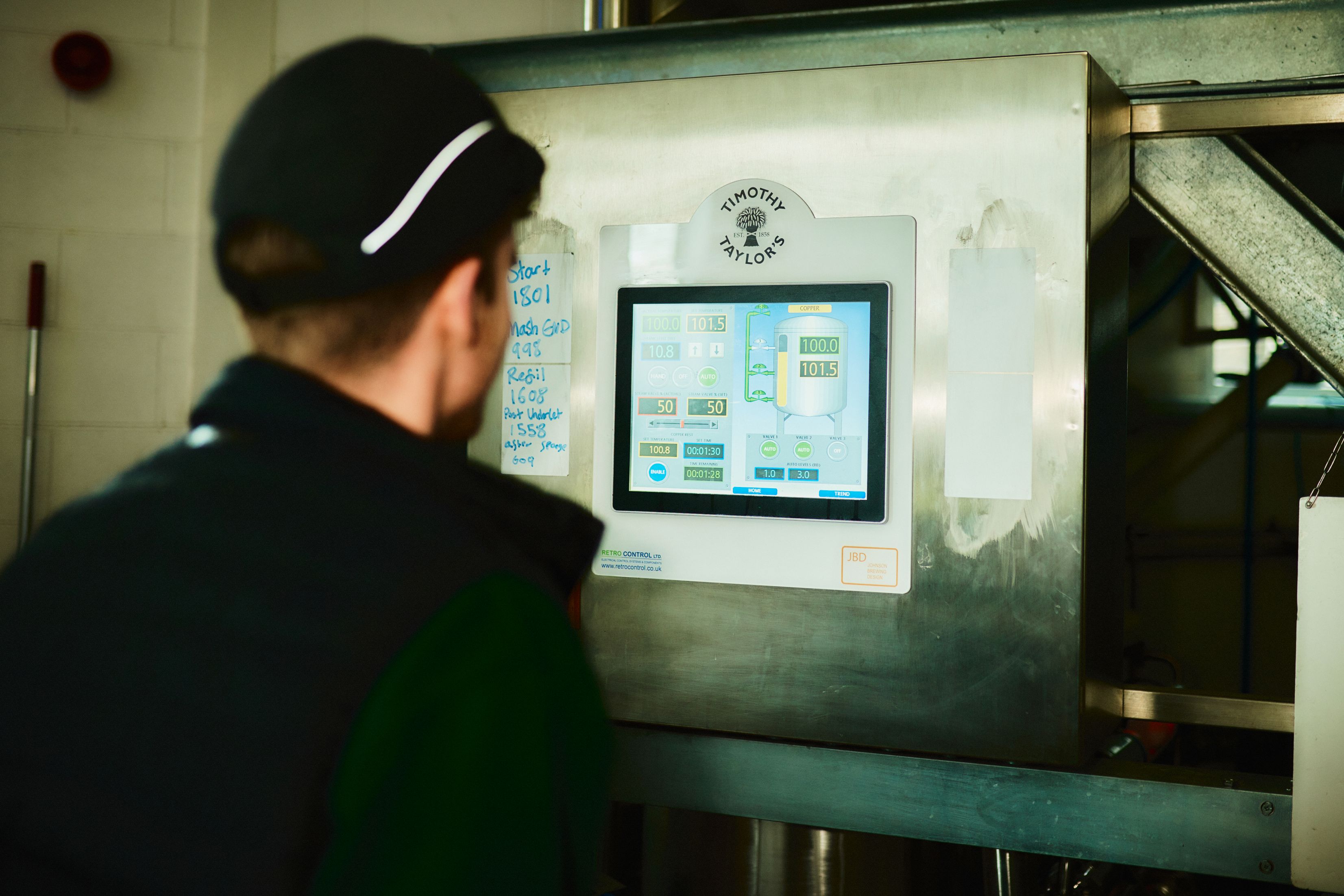 Timothy Taylor's team member watching brewing progress of digital screen.